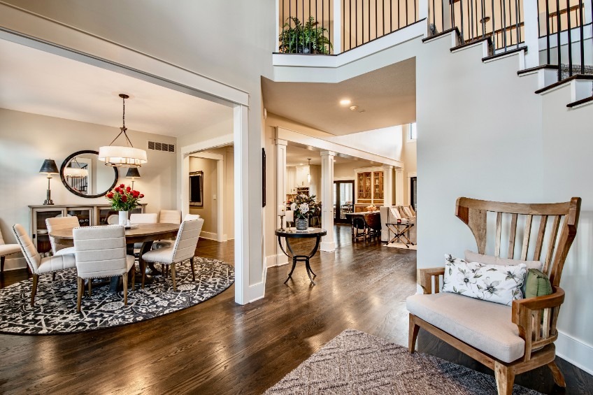 Remodeled two-storey entry hall opening onto a formal dining room with dark hardwood floors